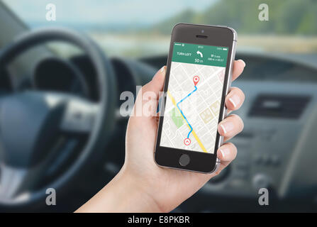Driver femmina seduto in macchina e di contenimento mobile nero smart phone con mappa applicazione di navigazione gps con percorso pianificato su Foto Stock
