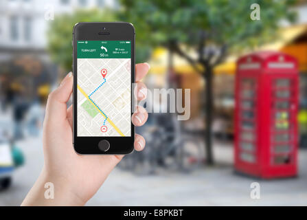 Femmina lato nero di contenimento mobile smart phone con mappa applicazione di navigazione gps con percorso pianificato sullo schermo. Stree sfocata Foto Stock