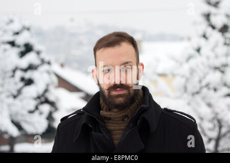 Ritratto di un giovane uomo in inverno solleva un sopracciglio Foto Stock