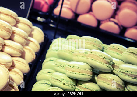 I tradizionali colorati macarons francese laici in panetteria. Tonica foto con effetto di filtro Foto Stock