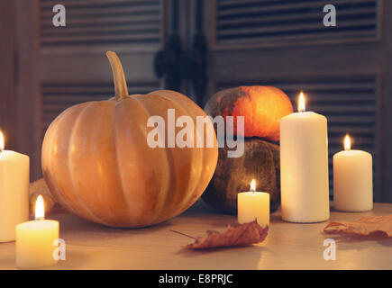 Candele accese e zucche. Luogo d'autunno. Rendimento di grazie Foto Stock