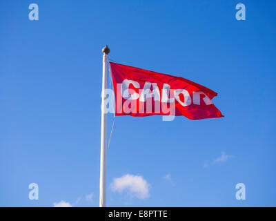 Un rosso e bianco pubblicità flag fornitore Calor di bottiglie di butano e propano gas per riscaldamento e illuminazione per la cottura Foto Stock