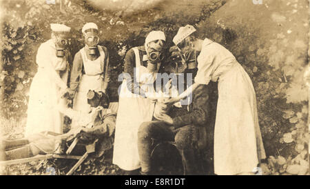 Una toccante fotografia di infermieri in maschere antigas alle trincee durante la prima guerra mondiale in Germania. L'immagine evidenzia il ruolo del personale medico in prima linea, affrontando i pericoli della guerra chimica. Foto Stock