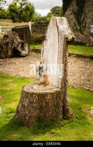 Tronco di albero formata in una semplice sedia da giardino Foto Stock