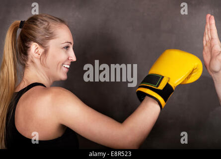 Sorridente boxer femmina in pratica il pugilato ring Foto Stock