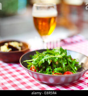 Un bicchiere di birra chiara con insalata del pub Foto Stock