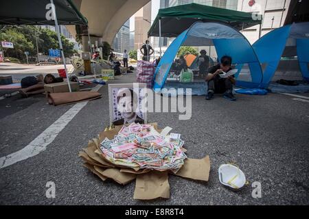 Hong Kong, Cina. Xiii oct, 2014. Pro-democratico manifestanti resto nelle tende mentre un ritratto di Hong Kong Chief Executive Leung Chun-ying è visibile sulla strada occupata durante il 16esimo giorno occupare il movimento in prossimità del capo di governo ufficio presso il Ministero della Marina di Hong Kong. Credito: Paolo Yeung ZUMA/filo/ZUMAPRESS.com/Alamy Live News Foto Stock