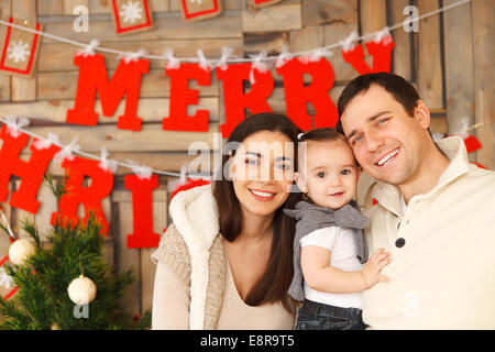 Sorridenti famiglia con vicino il sfondo di Natale Foto Stock