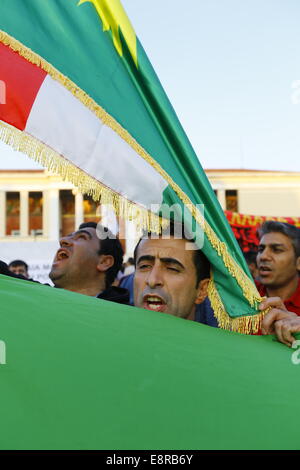 Atene, Grecia. 13 ottobre 2014. Un manifestante è coperto in una bandiera curda. Curdi che vivono in Grecia hanno protestato contro gli attacchi di uno Stato islamico (SI) sulla città di Kobane in Siria. La loro rabbia è stata prevalentemente orientata verso la Turchia e la inattività dell'esercito turco di venire in aiuto della città assediata. Foto Stock