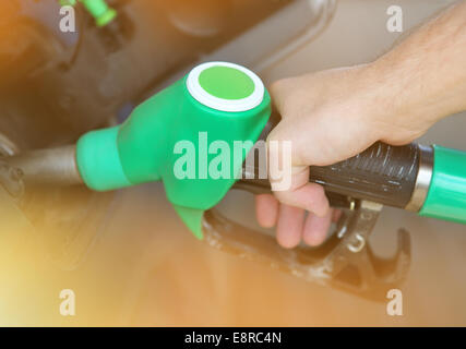 In prossimità di una mano di un uomo il rifornimento di un'auto con un gas pompa Foto Stock