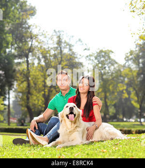 Coppia giovane seduto nel parco con un cane shot con inclinazione e spostamento lente Foto Stock