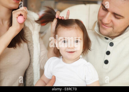 I genitori hanno di pettinatura bimbo di capelli Foto Stock