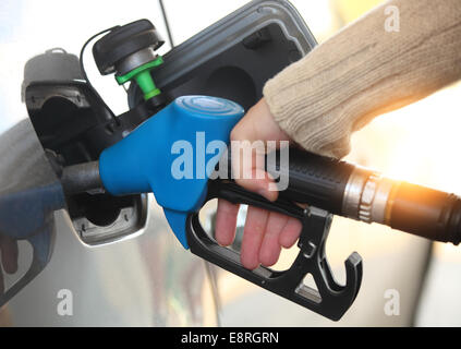 In prossimità di una mano mans ricarica della vettura con una pompa a gas Foto Stock