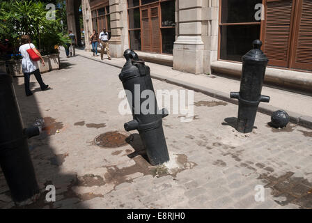 Vecchio di cannoni e palle di cannone incorporato in strada e utilizzato come controllo traffico barriere nel quartiere vecchio di Havana Cuba Foto Stock