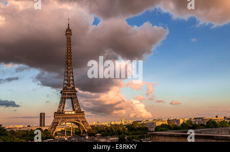 La Torre Eiffel è illuminato dal sole della sera come una nuvola passa overhead. Foto Stock
