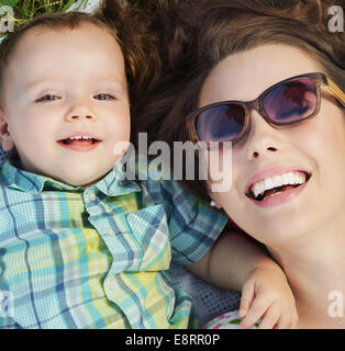 Attraente mom giacente sulla coperta con il suo bambino Foto Stock