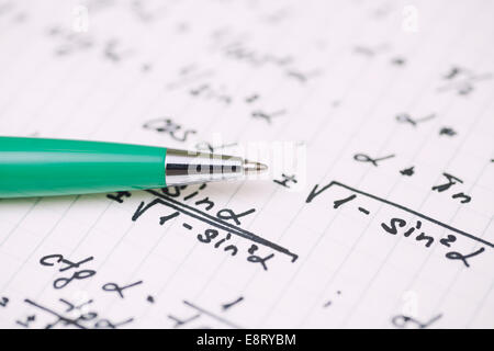 Equazioni di close-up. Compiti a casa. Risolvere problemi matematici. Focus sulla penna. Profondità di campo. Foto Stock