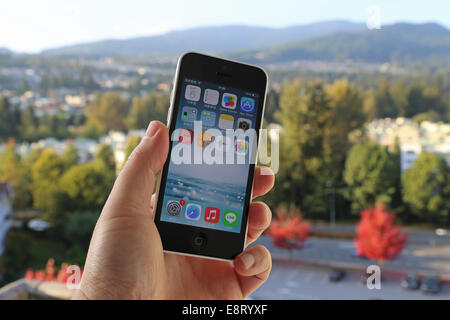 Coquitlam BC Canada - Ottobre 06, 2014 : Apple iPhone in una mano d'uomo, l'iPhone è uno dei più popolari telefoni intelligenti Foto Stock