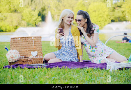 Due donne seduta sul manto colorato e i messaggi di testo Foto Stock