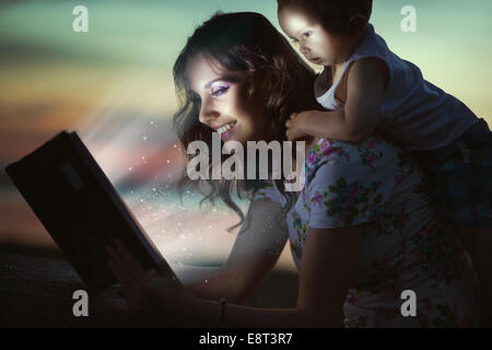 La mamma di lettura libro incredibile per il suo bambino Foto Stock