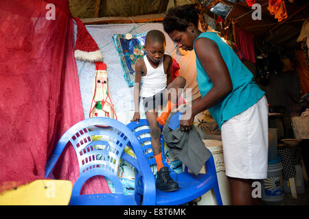 Medicazione di donna a suo figlio di 7 anni, per il suo primo giorno di scuola, campo Icare per rifugiati di terremoto, Fort National, Port-au-Prince Foto Stock