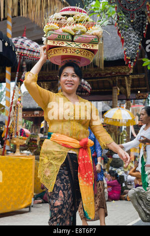 Una donna che trasportano sacrficial offerte, in una cerimonia del tempio, Pura Desa tempio, Ubud, Bali, Indonesia Foto Stock