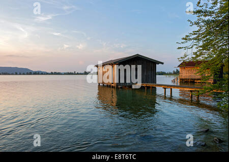 Boathouses sul lago Kochel nella luce della sera, Kochel am See, Alta Baviera, Baviera, Germania Foto Stock