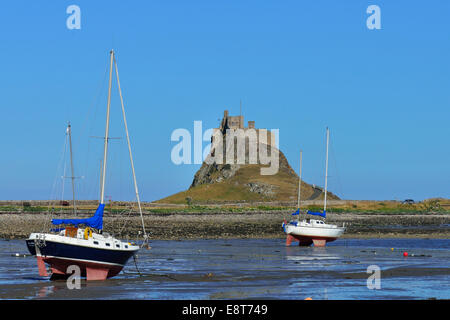 Barche a vela a bassa marea nella baia off Lindisfarne Castle, Lindisfarne in Northumbria, England, Regno Unito Foto Stock