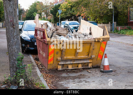 Saltare con il builder di rifiuti su una strada residenziale nel Nottinghamshire, England, Regno Unito Foto Stock