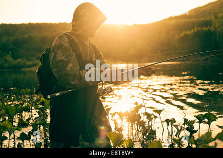 Mari uomo pesca nel lago Foto Stock