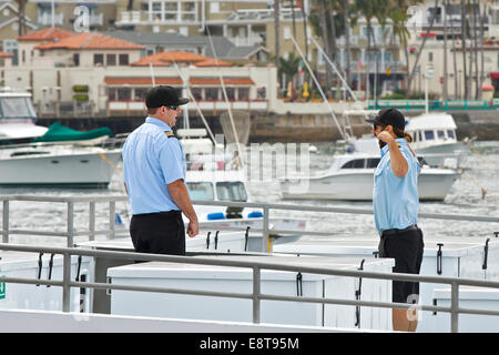 Deckhands sulla prua di un Catalina Express SeaCat arrivando in Avalon, Isola Catalina, California. Foto Stock