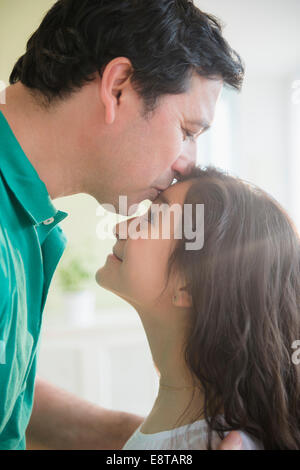 Padre ispanica kissing figlia sul fronte Foto Stock