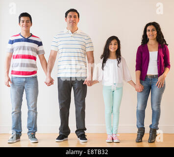 Sorridente famiglia ispanica tenendo le mani Foto Stock