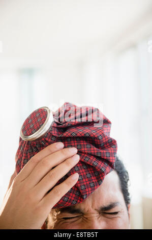 Razza mista uomo con confezione di ghiaccio alla testa Foto Stock