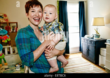 Madre caucasica tenendo il bambino in camera da letto Foto Stock