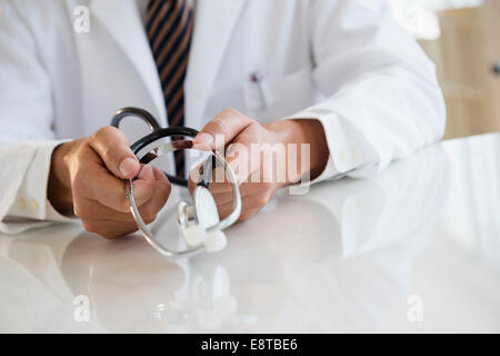 Close up di razza mista medico tenendo uno stetoscopio Foto Stock