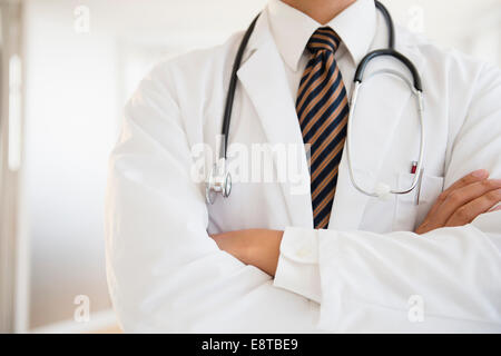 Close up di razza mista medico con le braccia incrociate Foto Stock