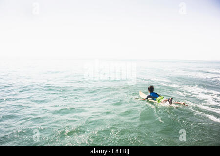 Ragazzo caucasico surf in oceano Foto Stock