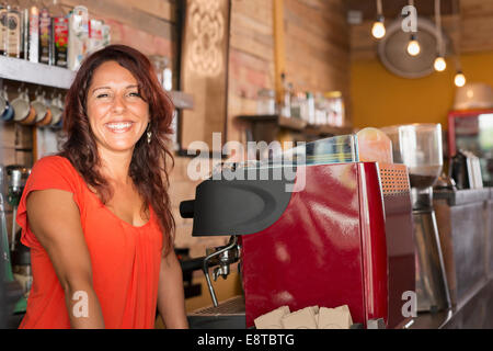 Sorridente ragazza ispanica lavorando in coffee shop Foto Stock