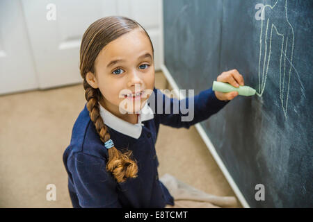 Razza mista ragazza disegno sulla lavagna Foto Stock