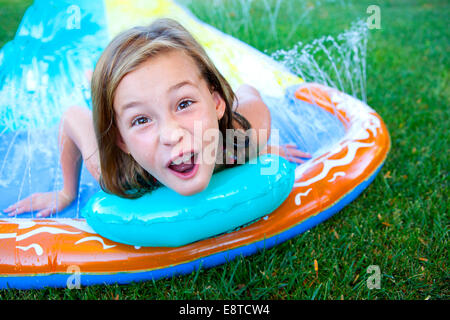 Caucasian ragazza sorridente sulla slitta di acqua Foto Stock