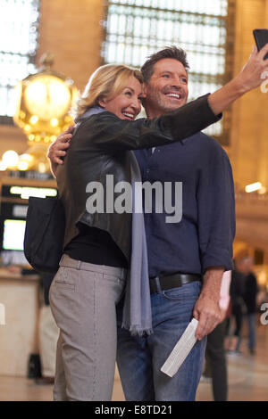 Coppia caucasica tenendo cellulare selfie in Grand Central Station, la città di New York, New York, Stati Uniti Foto Stock