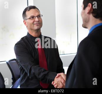 Uomini d'affari si stringono la mano in ufficio Foto Stock