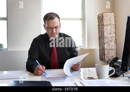 Imprenditore caucasico lavorare alla scrivania Foto Stock