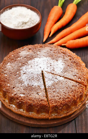 Torta di carote e carota fresca sul tavolo di legno Foto Stock