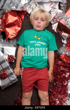 Bambino sulla commedia colpo di sfondo in un studio di indossare abbigliamento fresco al tempo di Natale, con presenta e carta da imballaggio, Foto Stock