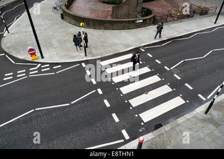 Vista in alto di un pedone che attraversa la strada su strisce bianche indicazioni stradali a un incrocio su Beech Street vicino al Barbican nella città di Londra. Foto Stock