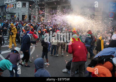 Barcellona, Spagna - 23 Settembre 2012: Revelers prendere la copertura da scintille e rumore forte durante il Correfoc per la chiusura della ''La Me Foto Stock