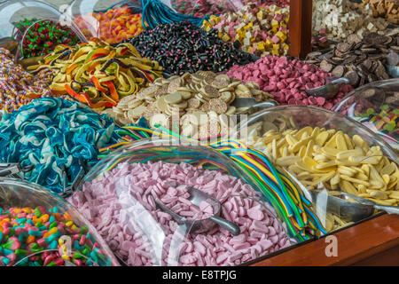 Selezione di multi-colore dolci caramelle e metallo che serve scoop stabilite per la vendita. Foto Stock