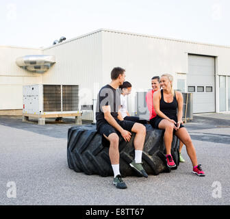 Montare gli amici a conversare mentre vi rilassate sul pneumatico Foto Stock